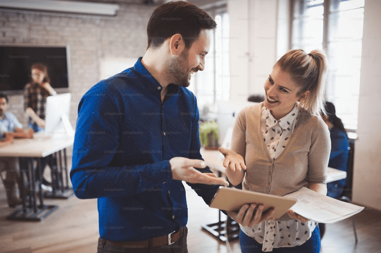 Man and woman smiling in office
